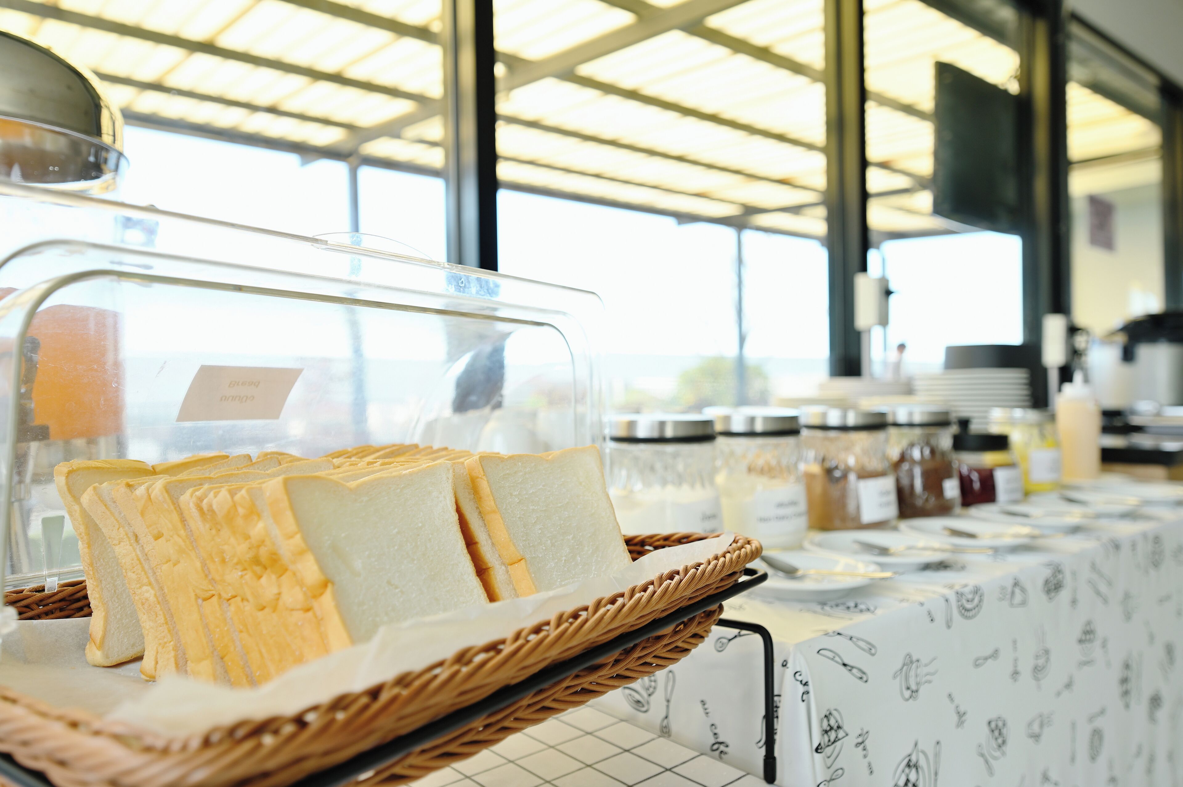 A buffet setup with bread and condiments.
