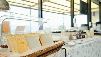 A buffet setup with bread and condiments.