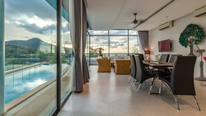Un comedor moderno con vista a una piscina y montañas.