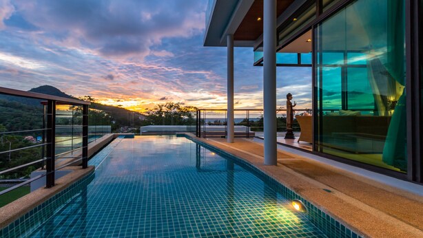 Una piscina infinita moderna con una vista despejada del atardecer y del paisaje circundante.