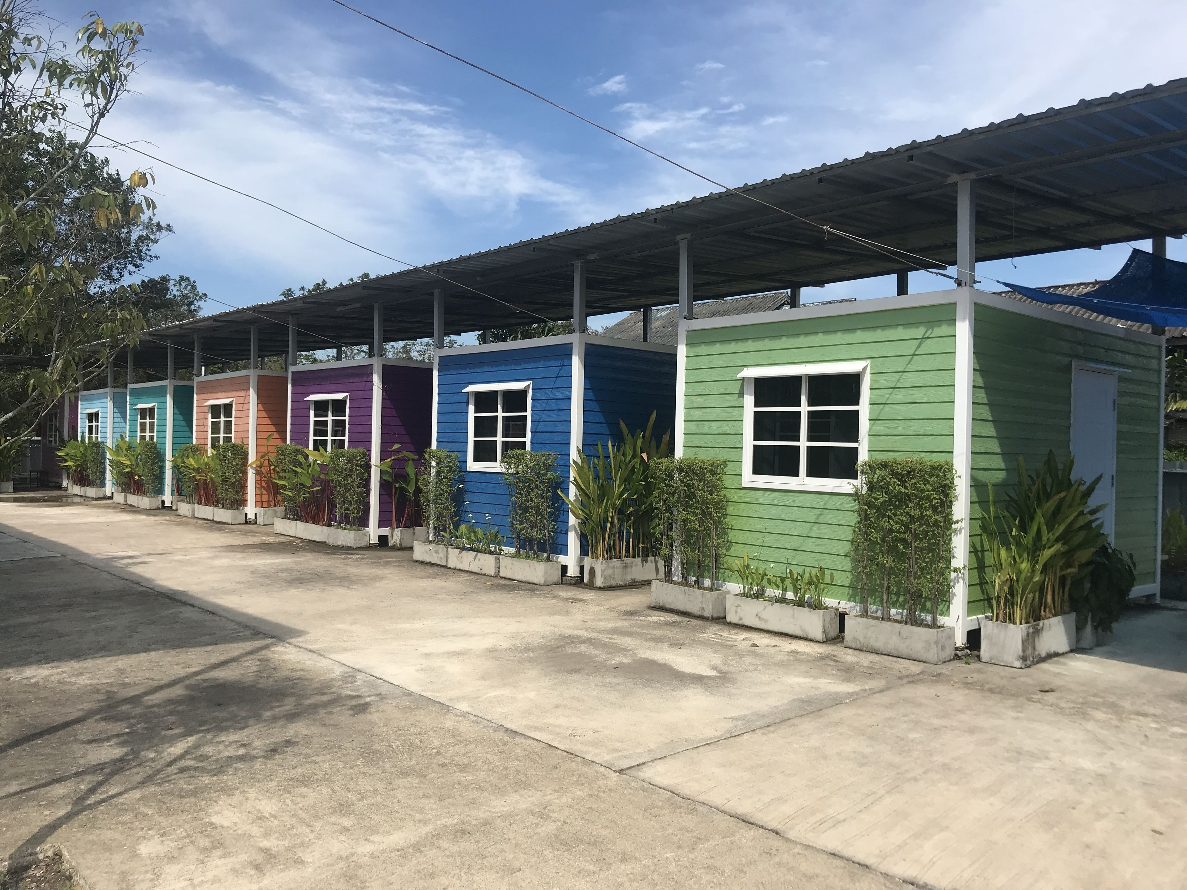 A row of colorful, single-story buildings with a covered outdoor area.