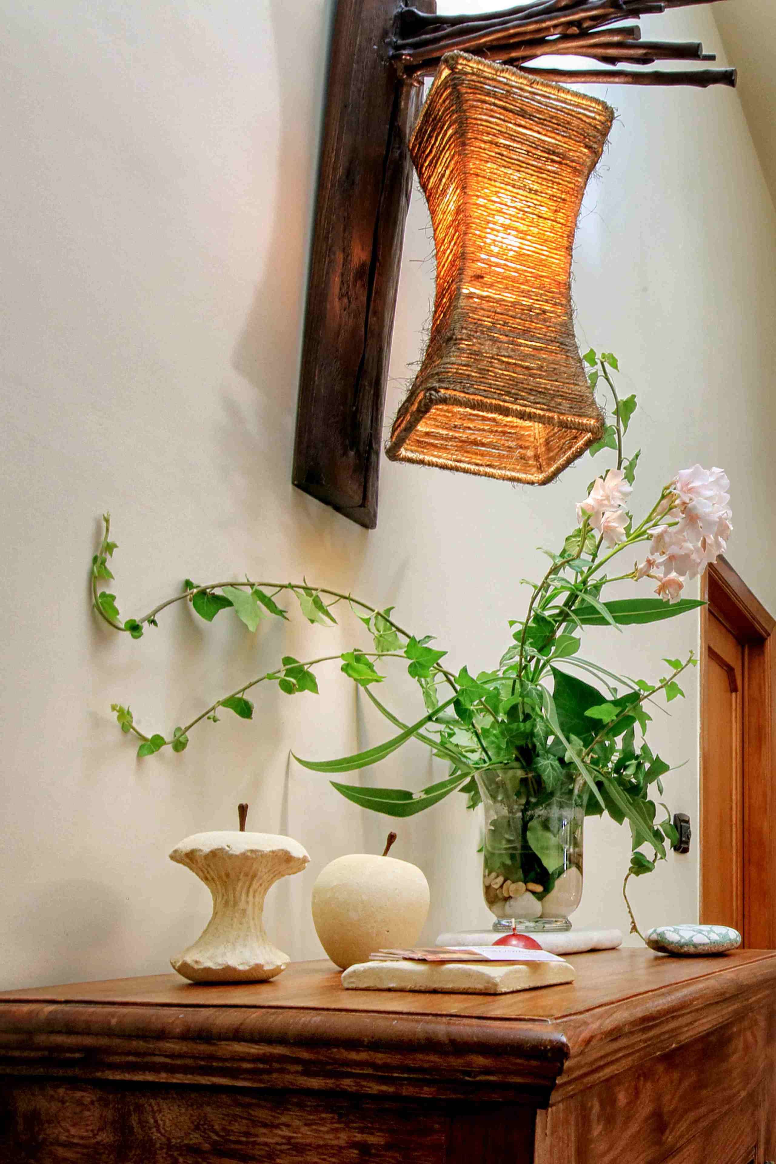 Une table en bois ornée d’un vase de fleurs, d’un livre et d’un objet décoratif.