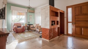 Un salon avec une cheminée, un coin repas et une grande porte en bois.