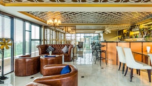 A modern bar area with leather seating, a bar counter, and a patterned ceiling. - 6 Avenue Surin by Lofty (Choeng Thale)