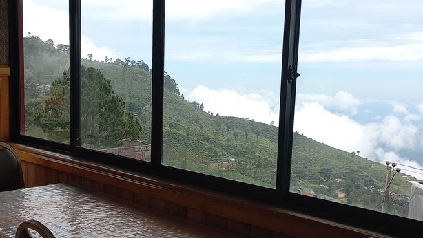 Una habitación con un amplio ventanal que ofrece vistas a un paisaje montañoso.