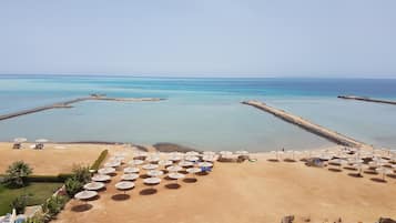 Een privéstrand, parasols, een strandbar