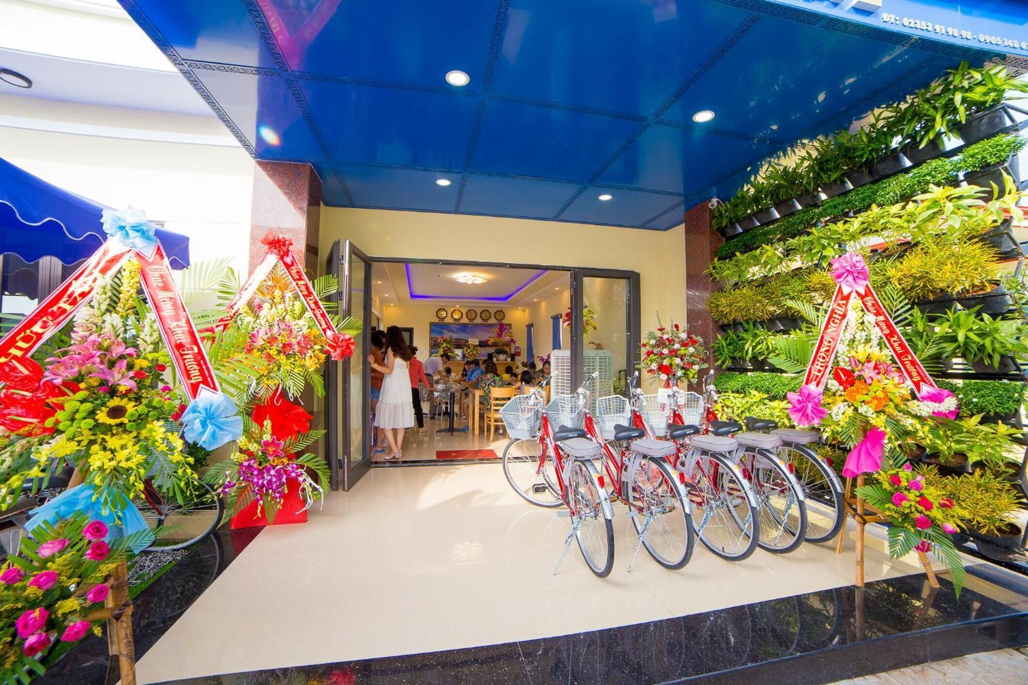 A flower shop with bicycles and a variety of flowers.