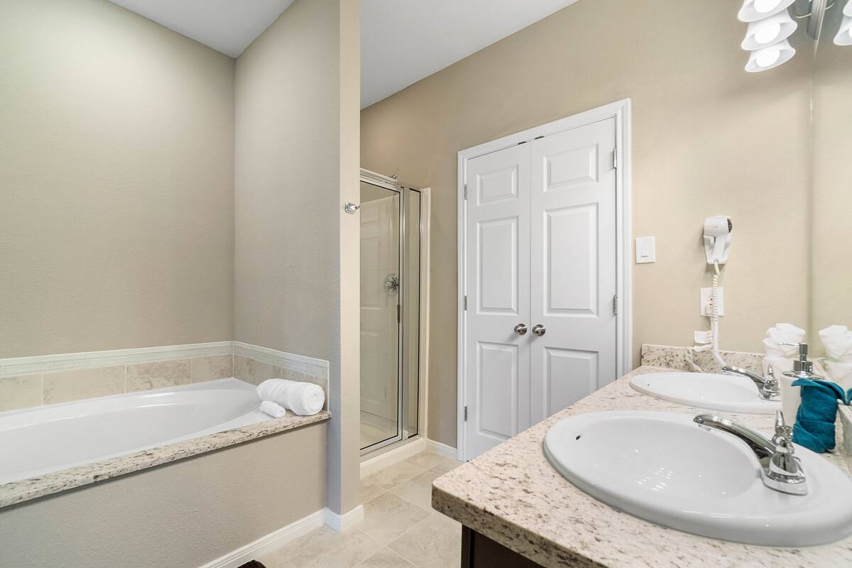 Un baño con bañera, ducha y dos lavamanos.