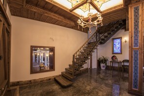 A grand staircase with a chandelier, a mirror, and a potted plant. - Bayezid Han Konak (Amasya)