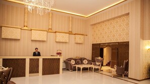A spacious lobby with a reception desk, plush seating, and a decorative chandelier. - Golden Shine Hotel (Baku)
