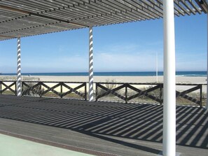 Un pasillo cubierto con vista a la playa y al océano.