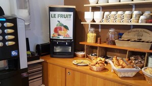 A breakfast bar with a coffee machine, bowls of cereal, and baskets of pastries. - Rev'Hotel (Leucate)