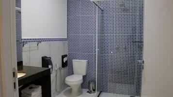 A bathroom with a toilet, sink, and shower.