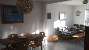 Un salon moderne avec un coin repas, comprenant un canapé, une table basse et une table à manger avec des chaises.