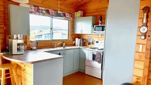 Una cocina compacta con una isla central, un microondas y una estufa.