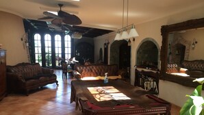 A spacious room with a billiards table, leather sofas, and a large mirror.