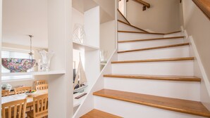 Una escalera con escalones de madera y una pared blanca.