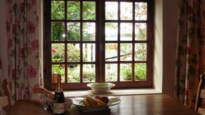 A dining table with a bottle of wine, a glass, and a plate of food. - Private pool in a beautiful, romantic retreat, offering peace and quiet (Noyant-Villages)