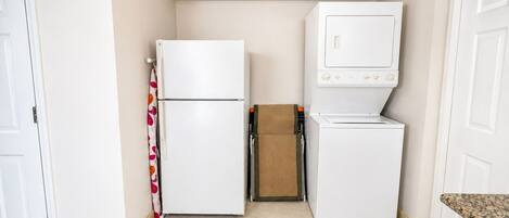 A compact kitchen with a refrigerator, microwave, and a small countertop.