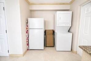 Una cocina compacta con refrigerador, microondas y una pequeña encimera.
