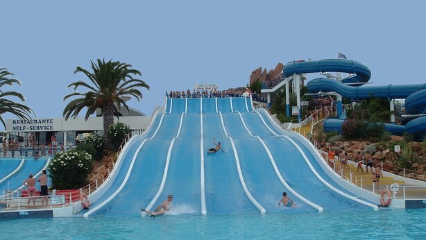 Un toboggan aquatique dans un parc d’attractions, avec une piscine au point d’arrivée.