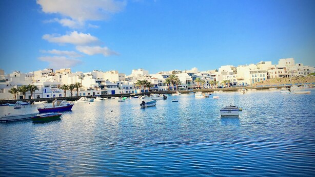 A coastal town with white buildings, a marina with boats, and palm trees. - 5 ***** Serena Studio with private chill out. (Arrecife)