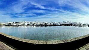 A waterfront promenade with a calm water body, lined with white buildings and palm trees. - 5 ***** Serena Studio with private chill out. (Arrecife)