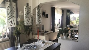 A modern kitchen with a marble countertop, hanging pendant lights, and a view of the living area through a large mirror. - Nestled between Rennsteig and the UNESCO Biosphere Reserve Thuringian Forest (Nahetal-Waldau)