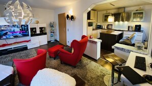 A modern living room with red chairs, a white sofa, and a globe light fixture. - Nestled between Rennsteig and the UNESCO Biosphere Reserve Thuringian Forest (Nahetal-Waldau)