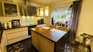 A compact kitchen with a central island, a built-in stove, and a coffee station. - Nestled between Rennsteig and the UNESCO Biosphere Reserve Thuringian Forest (Nahetal-Waldau)