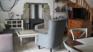A cozy living room with a fireplace, a sofa, a coffee table, and a TV. - CHARMING LITTLE HOUSE Belliloise  (Sauzon)