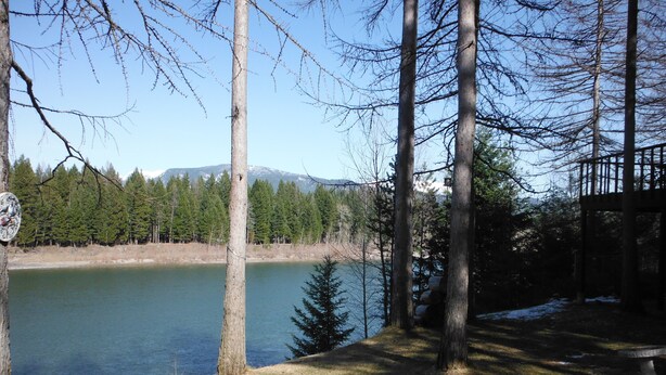 Un chalet au bord du lac offrant une vue sur une chaîne de montagnes.