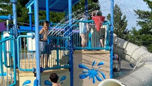 A water park with a blue play structure, a red water spout, and a water slide. - HUGE, 10 BEDS, FAMILIES, REUNIONS & RETREATS! LAKE FUN 1 MILE-FREE POOL PASSES! (Omaha)