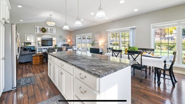 A spacious kitchen with a large island, pendant lighting, and a view to the backyard. - HUGE, 10 BEDS, FAMILIES, REUNIONS & RETREATS! LAKE FUN 1 MILE-FREE POOL PASSES! (Omaha)