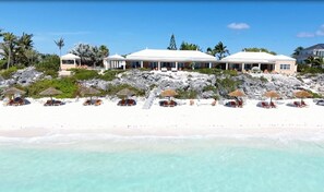 A beachfront hotel with multiple buildings, a sandy beach, and a clear view of the ocean. - Luxurious 4-12 Bedroom Sandy Beachfront  Villa ,24/7 Dedicated Concierge,peloton (Providenciales)