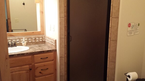 A bathroom with a sink, mirror, and a toilet. - Picturesque Lakefront Property for Your Next Mountain Escape (Island Park)