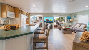A spacious living area with a kitchen, a dining area, and a seating area with a sofa and chairs. - Sandbars/Fishing/Boat Rental Dreamy Keys Gateway Home On The Water! (Tavernier)