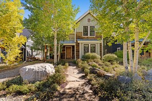 A two-story house with a stone pathway leading to the front door.