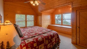 A wooden cabin bedroom with a bed, a ceiling fan, and large windows. - HAWKS RIDGE HIDEAWAY- Luxury Cabin & Great Get-Away! Amaazing view! (Bryson City)