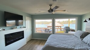 A bedroom with a bed, a TV, a ceiling fan, and a view of a dock and water. - Lake Hamilton Lakefront! Main Channel Large Decks & Boat Dock! Spectacular View! (Hot Springs)