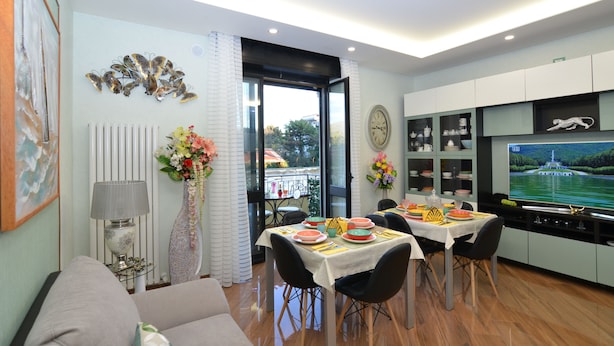 Una sala moderna con comedor, televisión y vistas al exterior.