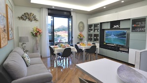 Una sala de estar moderna con un sofá, una mesa de comedor y un televisor.