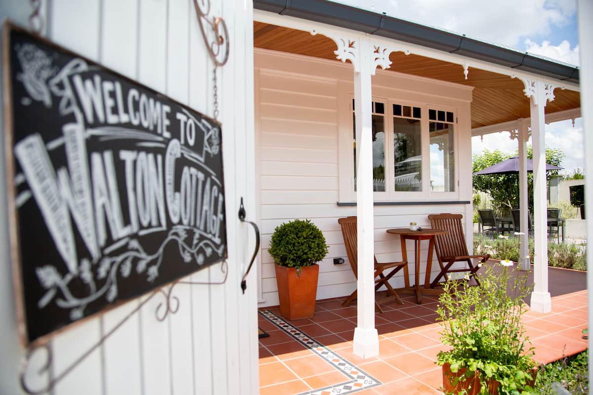A white building with a sign reading "Welcome to Walton Cottage."