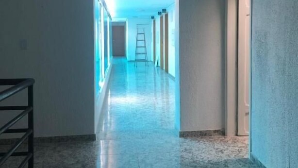 A hallway with a polished floor, a ladder, and a door on the right. - Hotel Butantã (São Paulo)