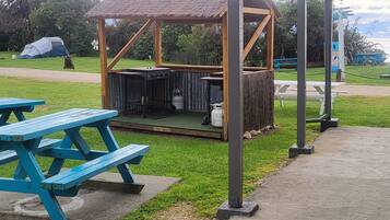 A covered picnic area with a grill, picnic tables, and a small shelter.