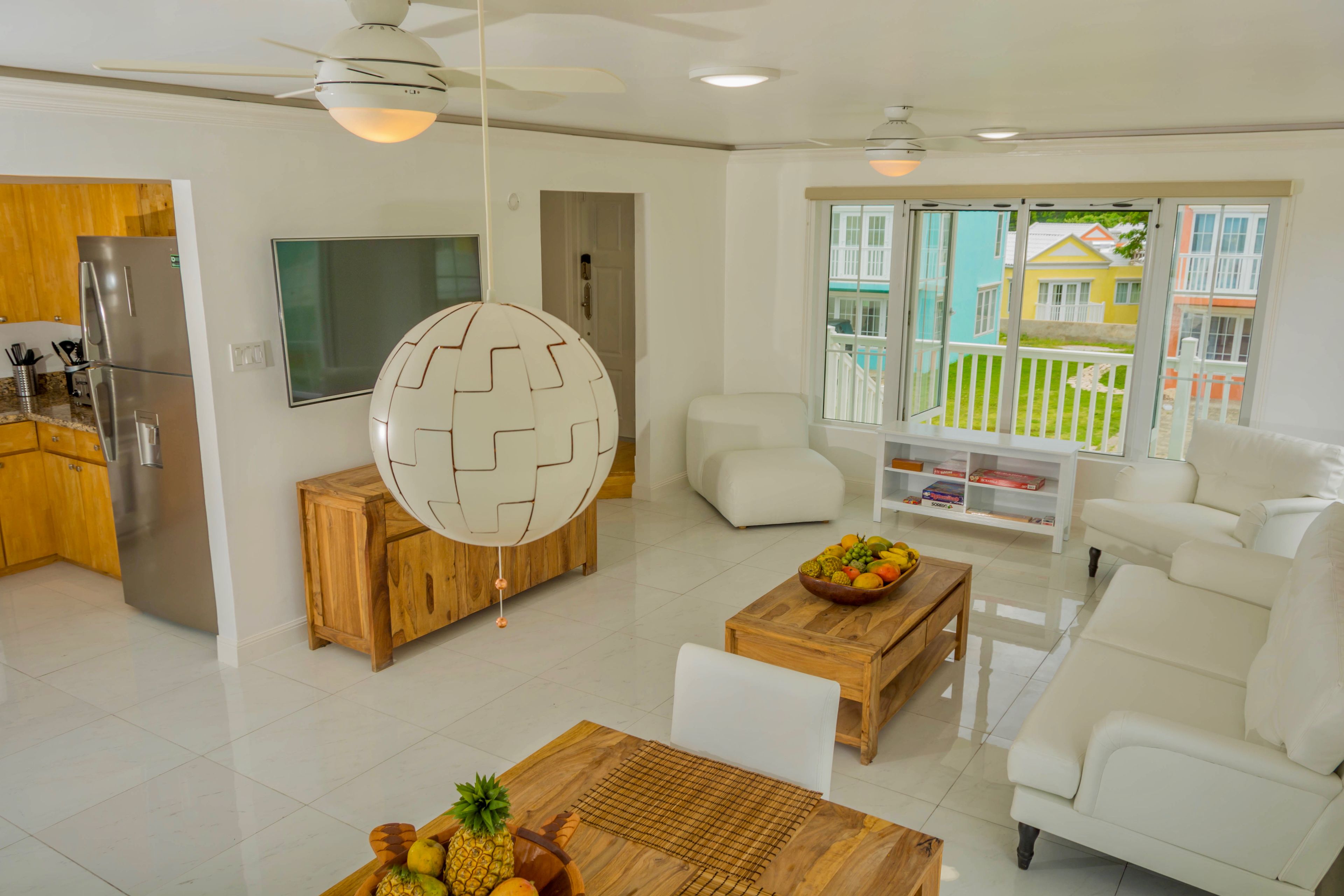 A modern living room with a white sofa, wooden coffee table, and a TV.