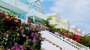 A row of colorful houses with a white staircase leading up to a porch. - Stunning Ocean View (Negril)