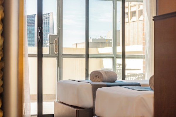 Quarto duplo com design assinado, sacada, vista para a cidade | Frigobar, cofres nos quartos, cortinas blackout