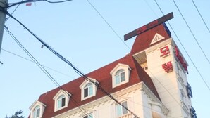 A multi-story building with a red roof and white facade, labeled "JUNG DONG JIN". - Jeongdongjin Motel (Gangneung)