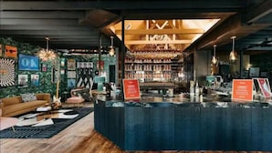 Un espace bar avec un comptoir, des étagères remplies de bouteilles et un panneau indicateur.